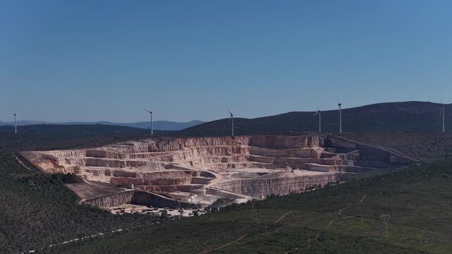 Limestone quarry with wind turbines on the background 