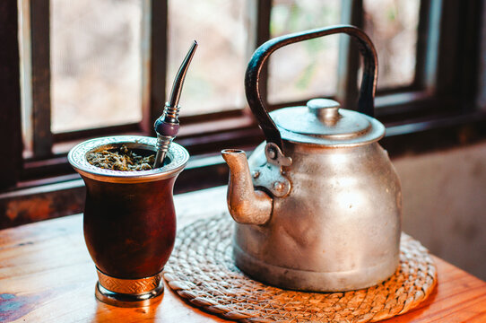 Mate y pava de acero frente a la ventana, bebida caliente tradicional argentina