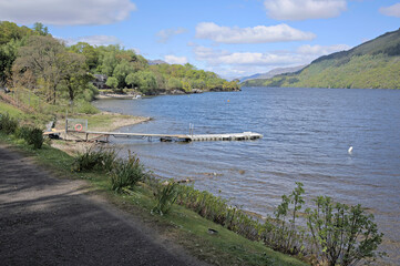View north up the loch past a jetty and house, from the minor road near Firkin Point, a viewpoint off the A82 on the west shore of Loch Lomond, OS map ref NN 338 007, Argyll and Bute, Scotland.