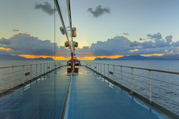Sea horizon at sunrise from deck of cruise ship with Sicilian coast near Palermo, southern Italy.