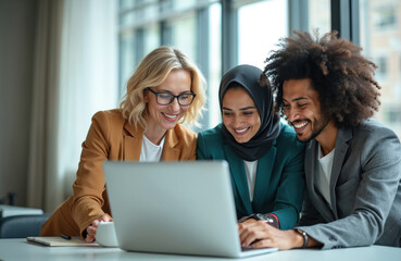 Diverse group of coworkers collaborate on laptop computer in modern office space. Smiling team discusses project strategy while sharing ideas and insights on digital device during busy workday.