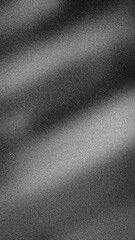 Dramatic abstract grainy monochrome gradient of black, white, and gray. High-contrast 4K backdrop template with cinematic spotlight effect