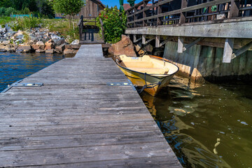 Rowboat moored at wooden dock by a boathouse in Axmar, Sverige