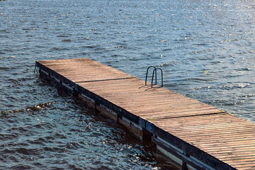 Wooden floating dock extending into sparkling water in Axmar, Sweden