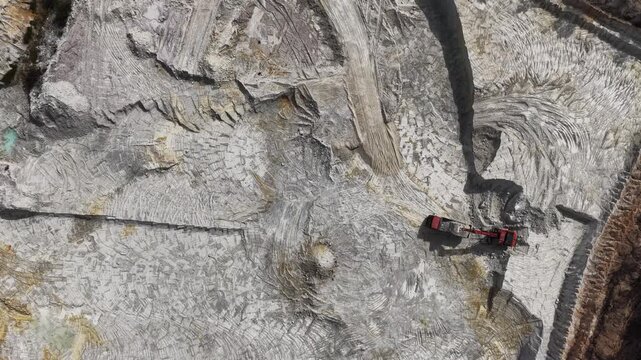 Escavator loads truck on a big quarry 