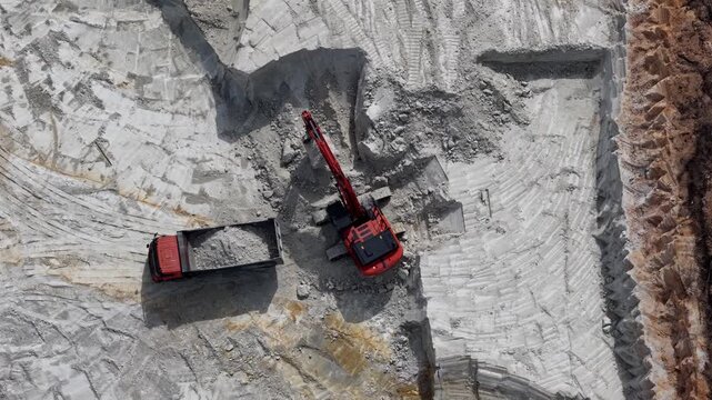 Escavator machine loading a truck in a quarry 