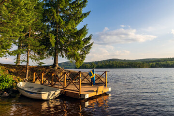 Swedish lake landscape with a dock and a rowboat