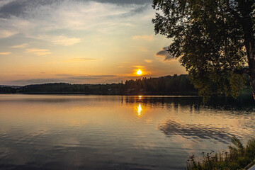 Golden sundown reflecting on a tranquil Sweden lake