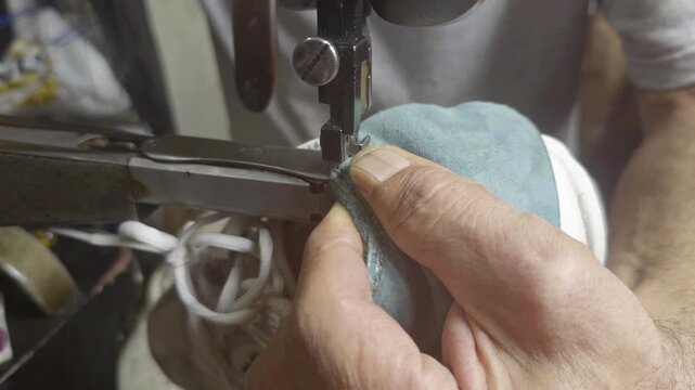 Shoe Repairman Repairs Torn Back of Sneakers by Stitching Them Up Footage.  