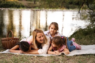 Mother and daughters having fun at a picnic by the river