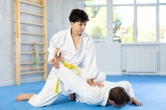 Adult man and teenage boy in kimono training judo fighting techniques - Powered by Adobe