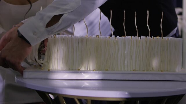 Couple shares wedding cake, Bride and groom enjoy their special cake moment together, Bride and groom cheerfully cut their elegant wedding cake amid joy and celebration
