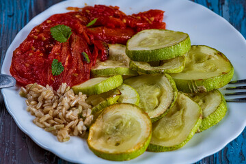 Baked zucchini with peppers and rice served on a rustic plate. A colorful and delicious homemade meal full of Mediterranean flavor, combining tender vegetables and perfectly cooked rice. 