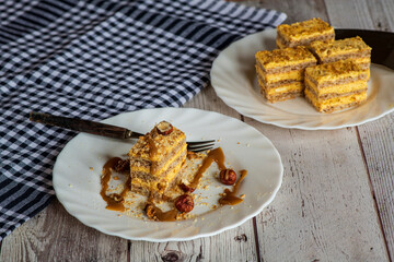 Sweet dessert cake with yellow cream and crunchy hazelnuts on top. The rich creamy filling and nutty flavor create a perfect homemade treat, ideal for pastry, bakery, or dessert themes.
