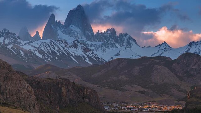 Dramatic time lapse of Mount Fitz Roy glowing at sunset above El Chalt&eacute;n, Argentina, with shifting clouds and vibrant light revealing the rugged Patagonian peaks, valleys, and snow-covered ridges