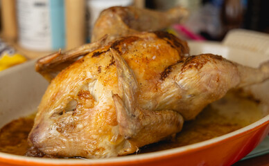 Gros plan sur un poulet rôti sortant du four.