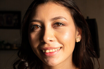 Smile of a beautiful young woman inside her home