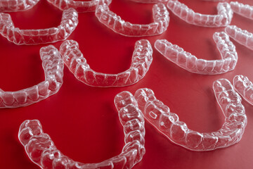 Invisible orthodontics cosmetic brackets on blue background. Tooth aligners, for beautiful smile. This invisible aligner showcases a modern approach to orthodontics and confidence in her appearance.