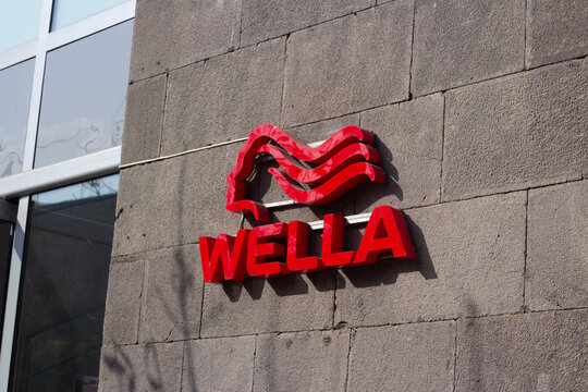 Yerevan, Armenia - November 8, 2025: Street photo. Red logo with female head on wall. Wella sign, major German hair care company specialized in styling, colorants sold to hairdresser. Black friday