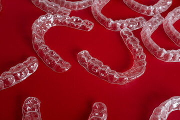 Transparent invisible dental aligners or braces aplicable for an orthodontic dental treatment. Invisible dental teeth brackets tooth aligners on blue background. Plastic braces dentistry retainers