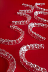 Invisible orthodontics cosmetic brackets on blue background. Tooth aligners, for beautiful smile. This invisible aligner showcases a modern approach to orthodontics and confidence in her appearance.