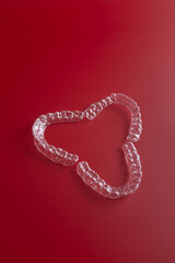 Transparent invisible dental aligners or braces aplicable for an orthodontic dental treatment. Invisible dental teeth brackets tooth aligners on blue background. Plastic braces dentistry retainers