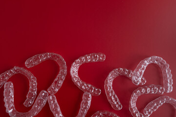 Invisible orthodontics cosmetic brackets on blue background. Tooth aligners, for beautiful smile. This invisible aligner showcases a modern approach to orthodontics and confidence in her appearance.