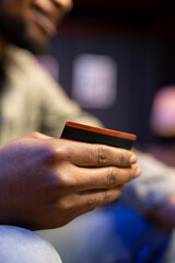 African american guy buying things with online shopping on laptop, typing credit card numbers to confirm a transaction and make purchase by placing the order. E commerce activity.