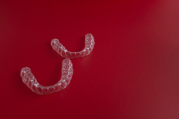 Invisible orthodontics cosmetic brackets on blue background. Tooth aligners, for beautiful smile. This invisible aligner showcases a modern approach to orthodontics and confidence in her appearance.