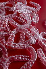 Transparent invisible dental aligners or braces aplicable for an orthodontic dental treatment. Invisible dental teeth brackets tooth aligners on blue background. Plastic braces dentistry retainers