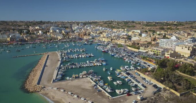 Malta: Aerial drone footage capturing the picturesque Marsaxlokk harbor in Malta. Drone flight footage