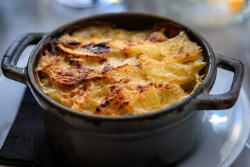 Potato gratin in a small cast iron pot at a French restaurant in Nice, France