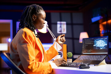 Programmer in living room office typing on keyboard, updating artificial intelligence neural networks, writing binary code scripts. Freelancing system administrator upgrading high tech AI