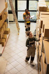 Staff member using a handheld scanner to update inventory records, managing products for e-business...