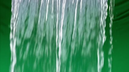 Dynamic waterfall curtain cascades creating a refreshing natural motion effect against a vibrant green backdrop for serene or energetic visual storytelling