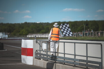 Naklejka premium Race official waving checkered flag at the finish line of a motorsport event
