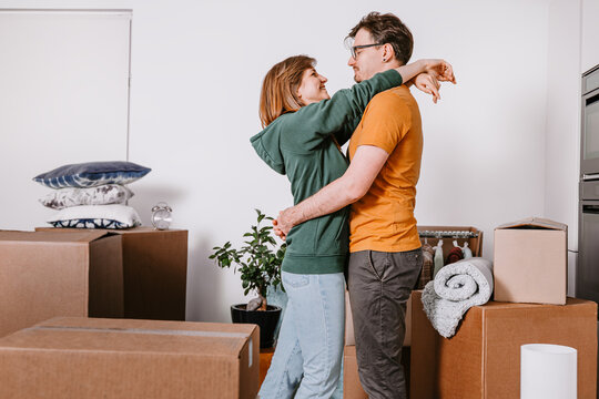 Couple Embracing While Moving Into New Home, Unpacking, Moving in