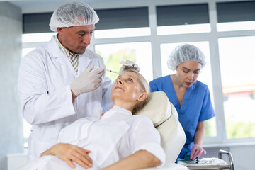 Obraz premium Woman getting procedure of injection contouring and for facial correction in cosmetology clinic