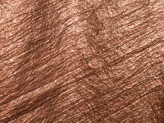 Copper background. Copper fabric. Bronze fabric background. Luxurious textile surface. Abstract bronze background or template. Fabric shiny glitter texture. Luxurious  background. Bronze color. Copper