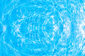 Blue water with ripples on the surface. Defocus blurred transparent blue colored clear calm water surface texture with splashes and bubbles. Water waves with shining pattern texture background.