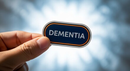 Holding Dementia: A hand gently cradles a sign bearing the word Dementia, set against a blurred background, evoking a sense of empathy and awareness regarding cognitive health challenges.