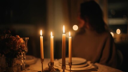 Four glowing candles illuminate a beautifully set dinner table, evoking feelings of romance and tranquility. The soft bokeh and gentle shadows enhance the serene, inviting mood
