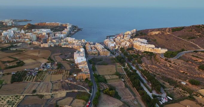 Malta, Comino island: Aerial drone footage capturing the picturesque coastal town of M arr on Gozo island. Malta. Highlights its harbor. Buildings. Fields. Drone flight footage