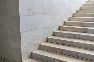 Indoor image of ascending marble stairs with darker outlines, in even lighting