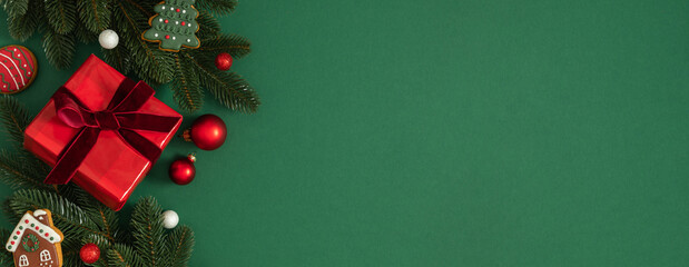 Christmas background: festive green backdrop with fir tree branches, gift box with velvet ribbon,...