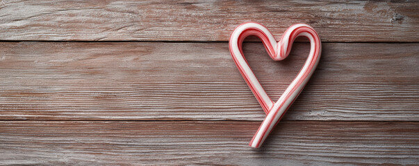 Candy cane heart shape christmas decoration on rustic wooden background festive sweet holiday treat