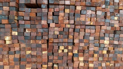 A close-up of neatly stacked wooden blocks showing natural brown, yellow, and dark wood textures. This photo is perfect for backgrounds, construction concepts, timber industry promotions, or interior 