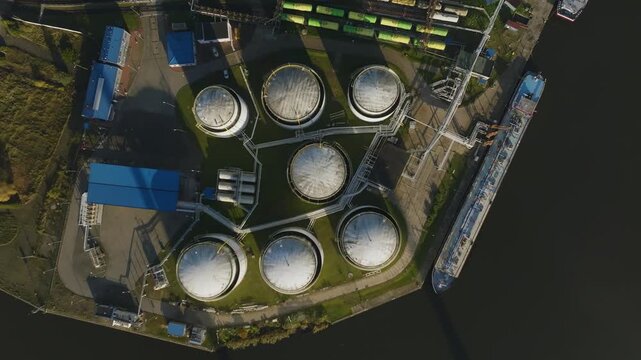 Aerial view of industrial oil terminal with fuel storage tanks near river