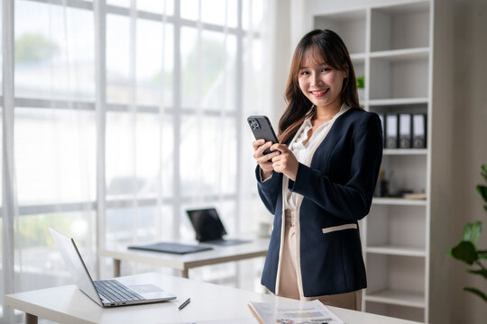 Young asian businesswoman using smartphone in modern office
