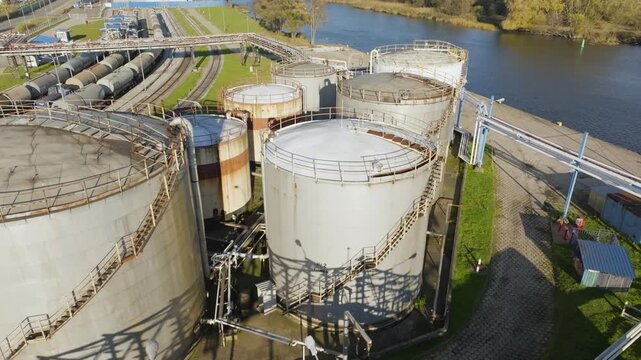 Aerial view of industrial oil terminal with fuel storage tanks by river